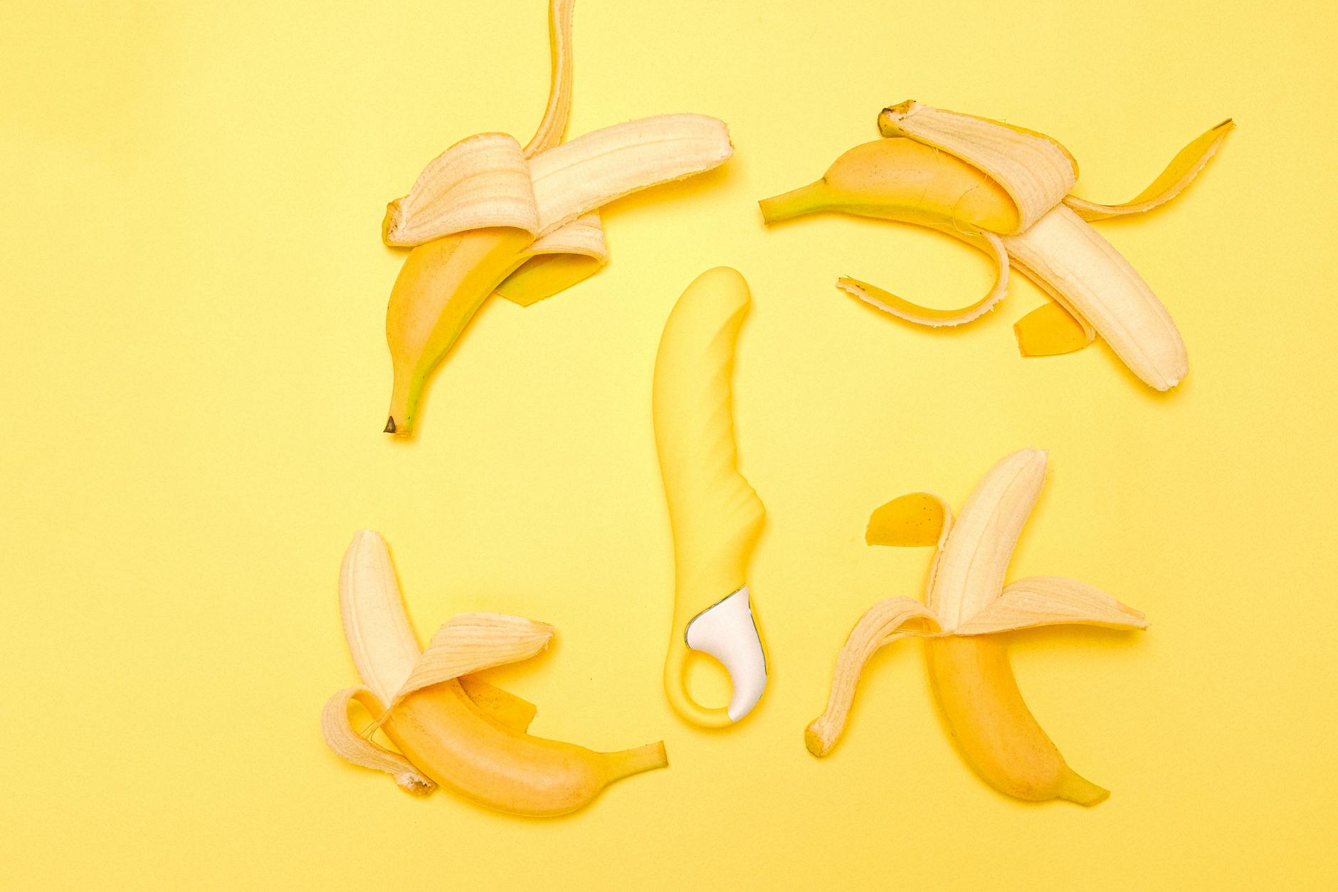 Yellow lemon vibrator on a yellow background surrounded by fresh citrus