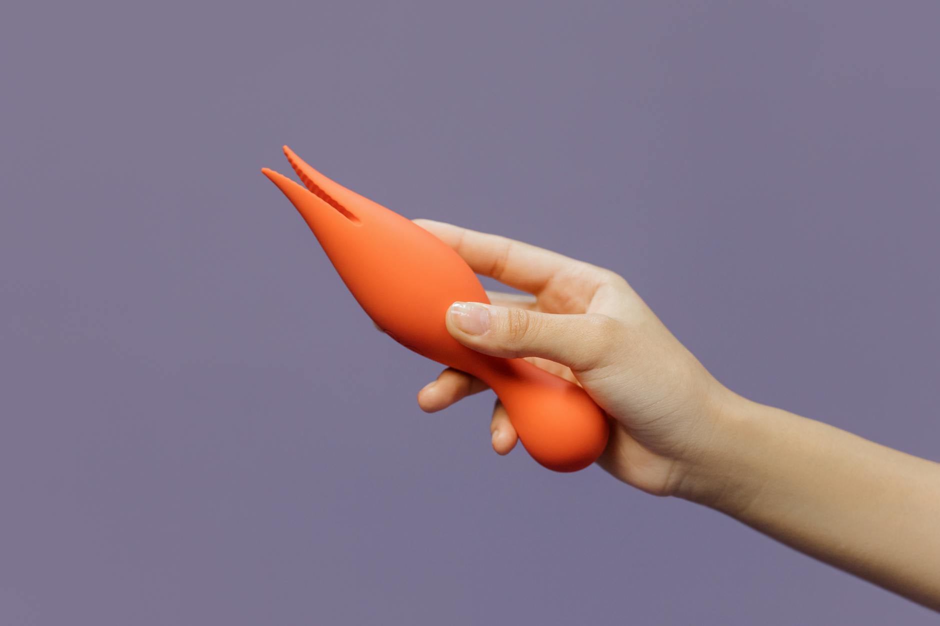 A hand holding a lemon vibrator, symbolizing intimacy and self-care in partnerships
