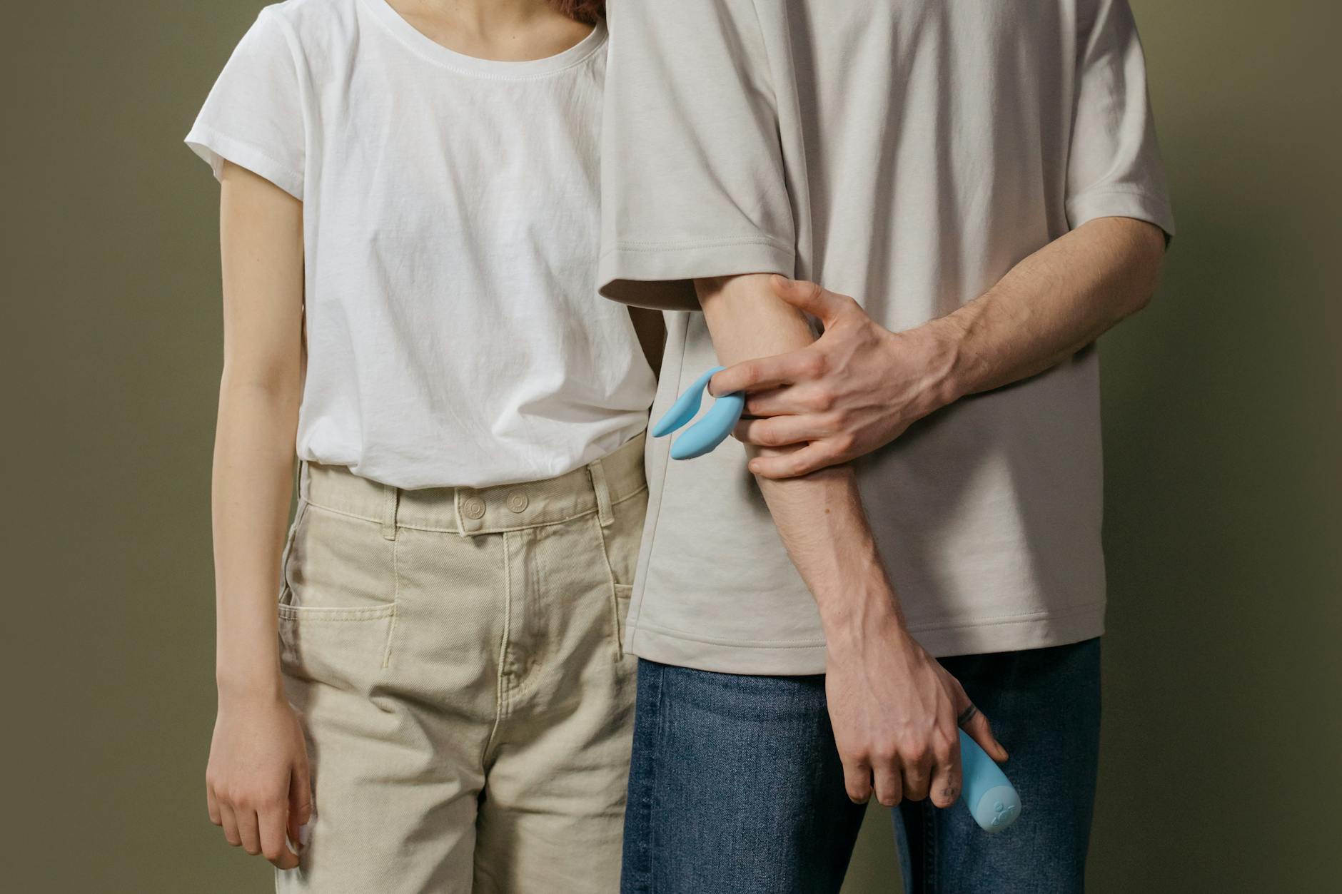 Hand holding a lemon-shaped vibrator against a purple backdrop
