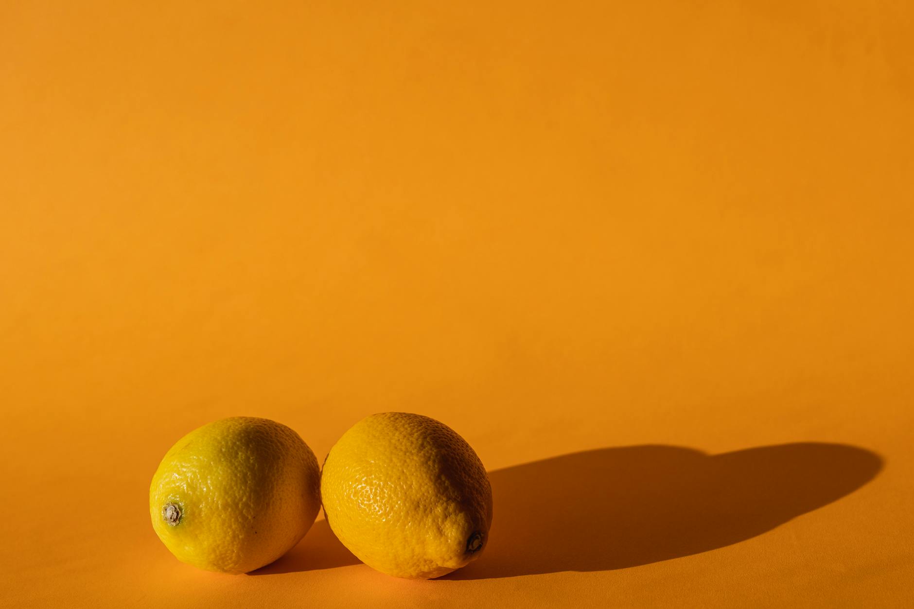 Ripe vivid lemons on bright yellow background